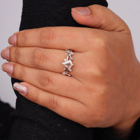 Nature-inspired vine ring featuring a kite cut cubic zirconia center stone with round accent stones and botanical leaf detailing