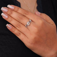 Nature-inspired vine ring featuring a kite cut cubic zirconia center stone with round accent stones and botanical leaf detailing