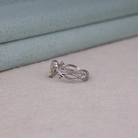 Nature-inspired vine ring featuring a kite cut cubic zirconia center stone with round accent stones and botanical leaf detailing