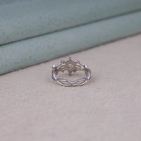 Nature-inspired vine ring featuring a kite cut cubic zirconia center stone with round accent stones and botanical leaf detailing