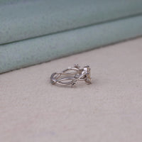 Nature-inspired vine ring featuring a kite cut cubic zirconia center stone with round accent stones and botanical leaf detailing