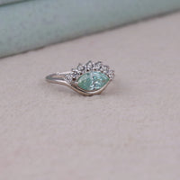 Ocean Bloom marquise cut aqua blue moissanite crown ring with round accent stones in a nature-inspired wave design