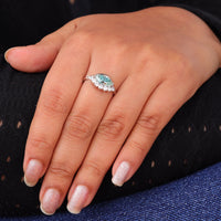 Ocean Bloom marquise cut aqua blue moissanite crown ring with round accent stones in a nature-inspired wave design