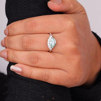 Ocean Bloom marquise cut aqua blue moissanite crown ring with round accent stones in a nature-inspired wave design