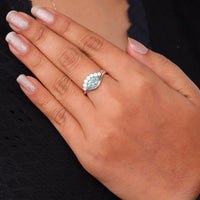 Ocean Bloom marquise cut aqua blue moissanite crown ring with round accent stones in a nature-inspired wave design