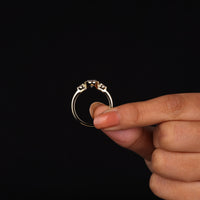Oval cut Moissanite engagement ring with bezel-set 10.00 × 7.00 mm center stone, pear cut side stones, elegant yellow gold finish, and minimalist three-stone design.