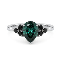 metalcolor:white Pear cut green moissanite accent stone engagement ring with round black side stones in a prong setting
