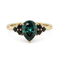 metalcolor:yellow Pear cut green moissanite accent stone engagement ring with round black side stones in a prong setting