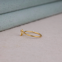 Pear cut moissanite solitaire engagement ring with clear center stone in prong setting and minimalist band design