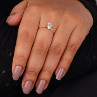 Pear cut moissanite solitaire engagement ring with clear center stone in prong setting and minimalist band design