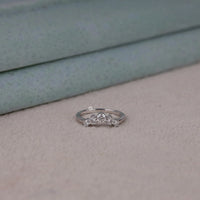 Round cut five stone moissanite curved ring with prong setting and elegant crown-inspired design