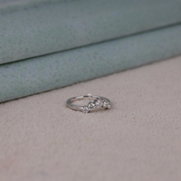 Round cut five stone moissanite curved ring with prong setting and elegant crown-inspired design