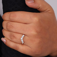 Round cut five stone moissanite curved ring with prong setting and elegant crown-inspired design