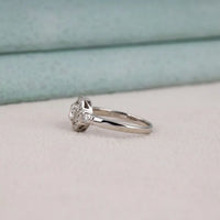 Silver ring with a diamond on a light gray surface