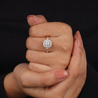 Close-up of a hand wearing a diamond ring on a black background
