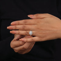 Close-up of a hand wearing a diamond ring on a black background