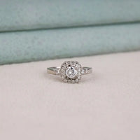 Silver ring with a diamond on a light gray surface