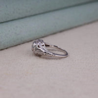 Vintage filigree engagement ring featuring a 5.00 mm round cut moissanite center stone in a decorative prong setting with intricate openwork design