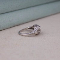 Vintage filigree engagement ring featuring a 5.00 mm round cut moissanite center stone in a decorative prong setting with intricate openwork design