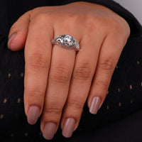 Vintage filigree engagement ring featuring a 5.00 mm round cut moissanite center stone in a decorative prong setting with intricate openwork design