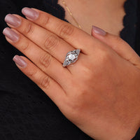 Vintage filigree engagement ring featuring a 5.00 mm round cut moissanite center stone in a decorative prong setting with intricate openwork design