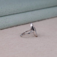 Vintage oval statement ring featuring round moissanite center stone, halo-inspired detailing, and intricate openwork luxury design