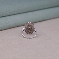 Vintage oval statement ring featuring round moissanite center stone, halo-inspired detailing, and intricate openwork luxury design