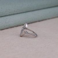 Vintage oval statement ring featuring round moissanite center stone, halo-inspired detailing, and intricate openwork luxury design