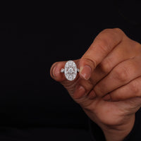 Vintage oval statement ring featuring round moissanite center stone, halo-inspired detailing, and intricate openwork luxury design