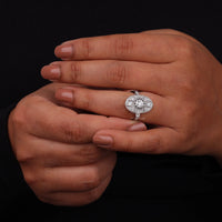 Vintage oval statement ring featuring round moissanite center stone, halo-inspired detailing, and intricate openwork luxury design