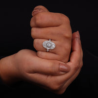 Vintage oval statement ring featuring round moissanite center stone, halo-inspired detailing, and intricate openwork luxury design