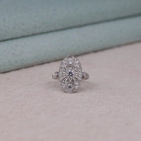 Vintage oval statement ring featuring round moissanite center stone, halo-inspired detailing, and intricate openwork luxury design