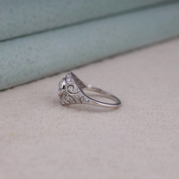 Vintage round cut moissanite bezel ring with 1.00 carat center stone, milgrain detailing, halo accents, and antique-inspired design