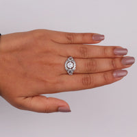 Vintage round cut moissanite bezel ring with 1.00 carat center stone, milgrain detailing, halo accents, and antique-inspired design