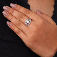 Vintage round cut moissanite bezel ring with 1.00 carat center stone, milgrain detailing, halo accents, and antique-inspired design